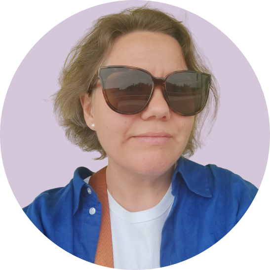 A picture of Lina Bodestad, a woman with short brown hair, blue shirt and sunglasses.